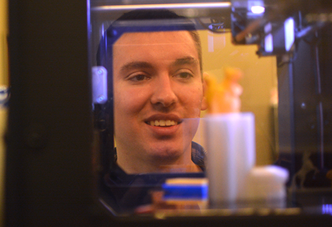 Kody Gann, senior technology major, watches items produced by the Kent State 3D on Sept. 14. Photo by Jacob Byk.