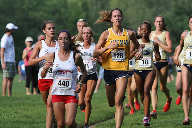 Sophomore Paige Foster looks at the time clock during the first lap of the Tommy Evans Invitional at Firestone Metro Park, Sept. 6. Photo by Chelsae Ketchum.