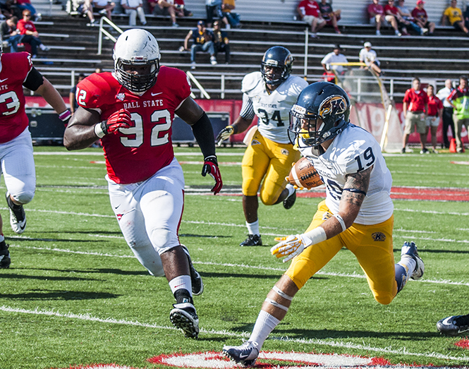 Senior defensive tackle Nathan Ollie attempts to bring down Kent State wide receiver Josh Boyle during the Homecoming game Saturday, Oct. 12, 2013. Kent State lost the game 27-24. Photo by Ashlee Hayes