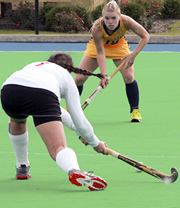 Miami's Emily Gruesser (right) is struck by Kent's senior midfielder Alyssa McFerren's stick after she passed the ball on Oct. 27, 2013 at Murphy-Mellis Field. Miami fell to Kent, 3-1. Photo by Matt Hafley.