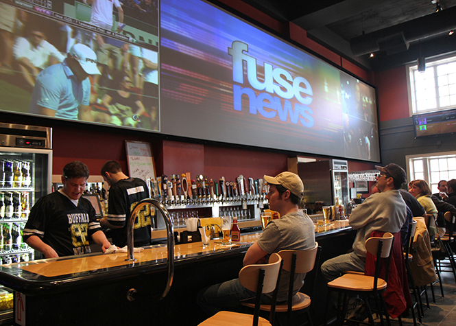 Patrons at Buffalo Wild Wings in downtown Kent watch the new location's big screen televisions above the bar on Saturday, April 6. Photo by Shane Flanigan.