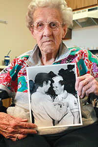 Helen Kolp, World War II first sergeant in the Women's Army Corps, holds a photograph of herself receiving the Department of Army Commendation Medal at Fort McClellan in 1963. Photo by Kristi Garabrandt.