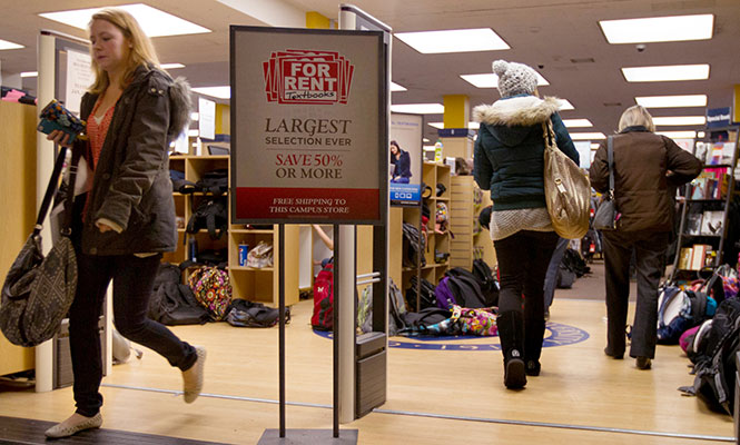 Junior communication studies major Megan Gumpf walks out of the busy bookstore on the first day of the spring semester, Monday, Jan. 13, 2014. The doorway is lined with backpacks because students are not permitted to bring them inside with them.