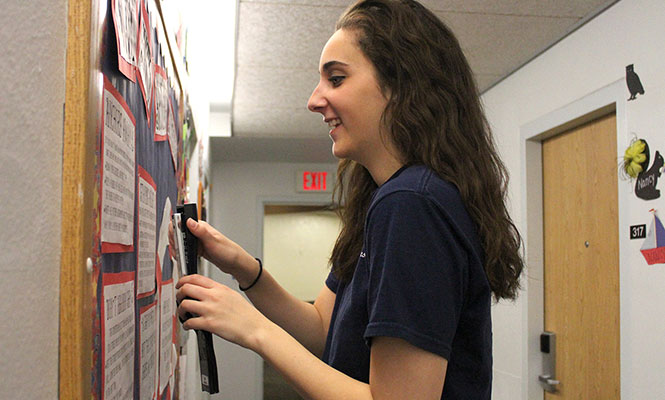 Resident Assistant Meghan Blaha updates one of the bulletin boards in Olson Hall on Monday, Jan. 27, 2014.