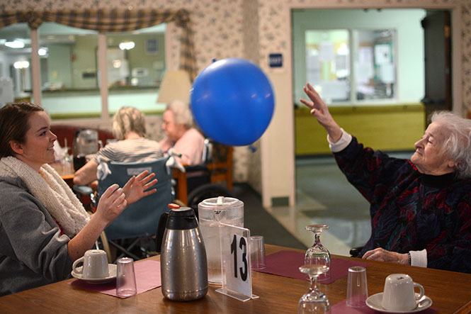 Karianne Johnsen, junior advertising major, tosses a balloon with Mary Nicolino, a 98-year-old resident of Stow-Glen Retirement Home, during the Martin Luther King Jr. "Just 4 A Day" event put on by Kent State Hillel Monday, Jan. 20, 2014. It is a common exercise between the facility's residents.