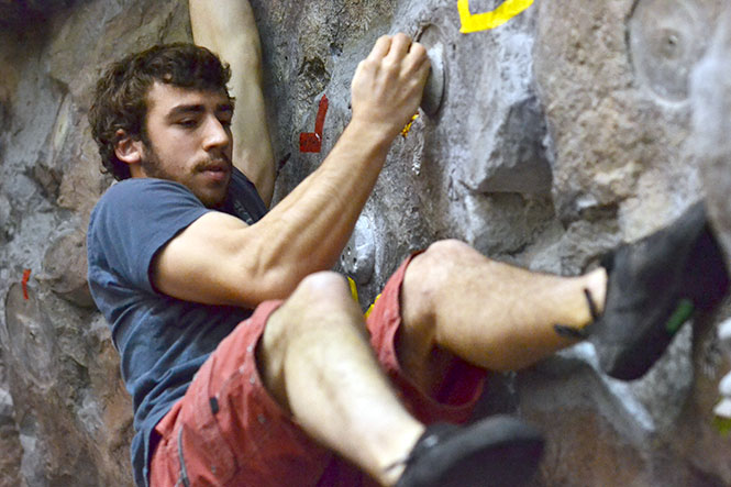 Sophomore exercise science major Antonio Torres practices a technique called bouldering Tuesday evening, Feb. 11, 2014, at the Kent Recreation and Wellness Center's rock wall.