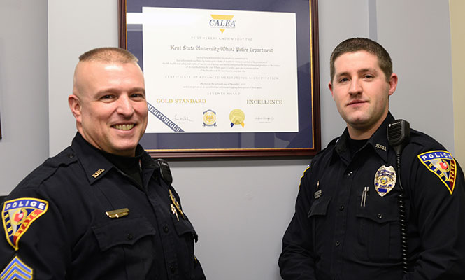 MELANIE NESTERUK | DAILY KENT STATERSargeant Wayne Parker and Officer Kevin Hammer stand in front of the Kent State Police's 7th Certificate of Accreditation Sunday, Feb. 16, 2014.