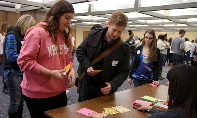 Freshman speech pathology and audiology major, Dylan Still-Pepper (right), and freshman Sarah Lovejoy (left) recieve a baby girl at The Game of Life event on Wednesday, Jan. 29, 2014. The event was a recreation of the popular board game "Life" as a way to create an interactive inequality simulation.