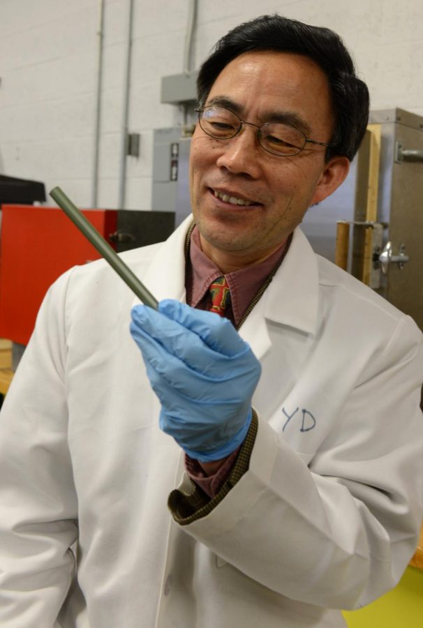 Professor Yanhai Du holds a fuel cell in the Van Duesen Hall lab on Monday, Feb. 10, 2014. Du hopes to promote fuel stem cell research to help teach students technology in a more energy efficient way as fuel cells don't use Hydrogen.