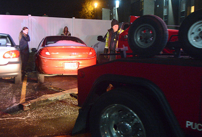 Sophomore fashion merchandising major Ashleigh Lentz (left) negotiates with a Kent city towing employee as her car is set up to be towed from Eagle's Landing, Jan. 16, 2014. Lentz had to go to an ATM to get cash, since under current law, towing companies don't need to accept credit cards.