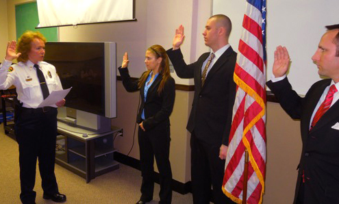 Kent Police Department Chief Michelle Lee swears in Lindsey Llewellyn, Michael Carnahan and Matthew Brooks last week. The three new officers are starting field training this week and in about three months will start regular officer duties, such as doing some of the new foot patrols a state grant is providing for. Photo courtesy of kentpd.org