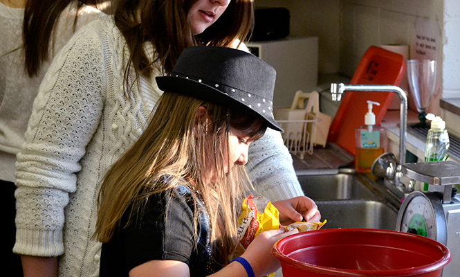 Kirsten Seman, 9, from Ravenna adds chocolate chips to a healthy desert for the K.I.D.S. program at Nixson Hall on Thursday, Mar. 6, 2014. Nutrition Outreach graduate and undergraduate students are working with children and parents from Portage County to educate them in nutrition and dietetics as part of an eight week program.