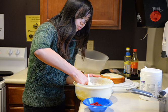 Jessica Becker, freshman English as a second language major, helps to decorate a cake she and her friends baked in the Stopher Hall kitchen, Wednesday, March 12, 2014.