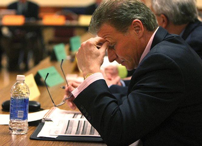 Provost fellow Jarrod Tudor reviews notes at Monday afternoon's faculty senate meeting in the governance chambers, March 17, 2014.