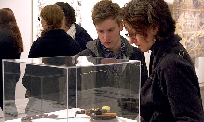 Noah Gfell and Cheril Walker, family of the undergraduate runner up Eli Gfell, viewed various works of art at the 2014 Student Annual Art Gallery Thursday, Mar. 6, 2014.