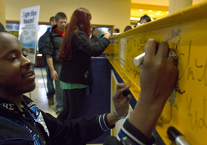 Junior Air Traffic Control major Joseph Lastery signs the beam that will be going up in the College of Applied Engineering, Sustainability and Technology in the atrium of the Student Center, Wednesday March 19, 2014.