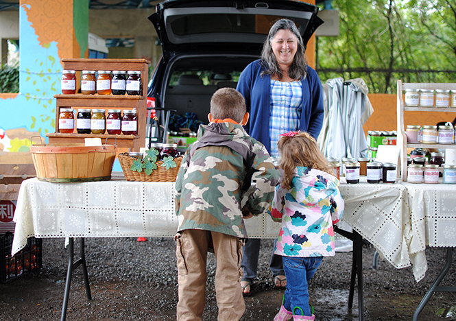 A vendor talks to tiny customers at the Haymaker Farmer's market, Sept. 8, 2012.