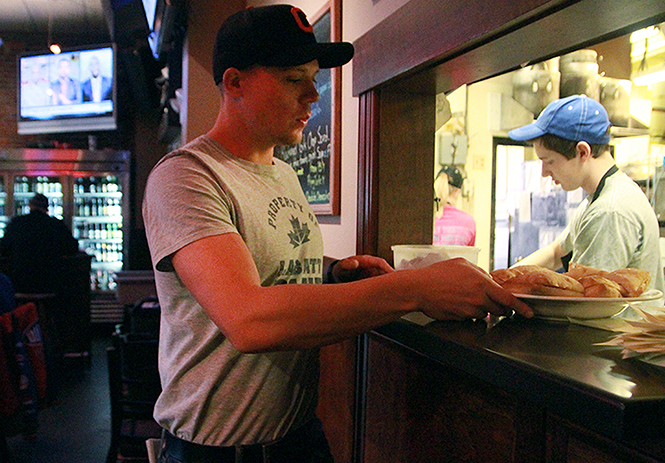 A waiter serves food to hungry customers at Ray's Place, April 8, 2014.