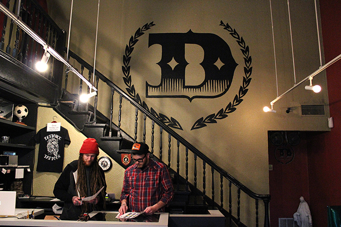 Workers Mike Jagel (left) and Chase Ogle (right) wait for customers to come into Defiance Tattoos on April 7, 2014. Defiance Tattoos was voted best tattoo and piercing parlor in Kent.