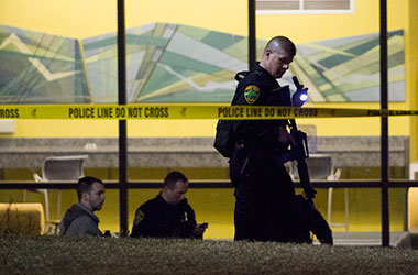 A law enforcement officer searches for evidence outside of Bowman Hall after a shot was fired at Kent State University, Wednesday, April 2, 2014.