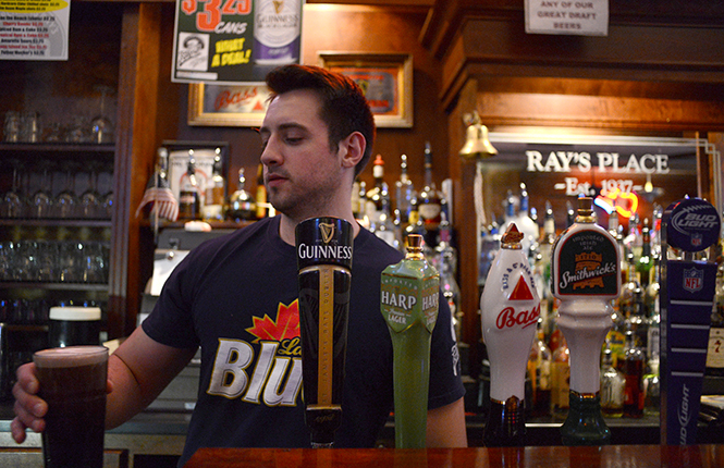 Ray's bartender Angelo Cataldo, junior exercise science major, pours a draft in downtown Kent, Tuesday night, April 8, 2014.