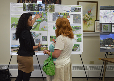 Kent State graduate architecture student Parva Majidi presents her design, titled "Creek Revitalization," to a resident of Garrettsville, Ohio at an open meeting held Friday, July 25 in the village city hall.