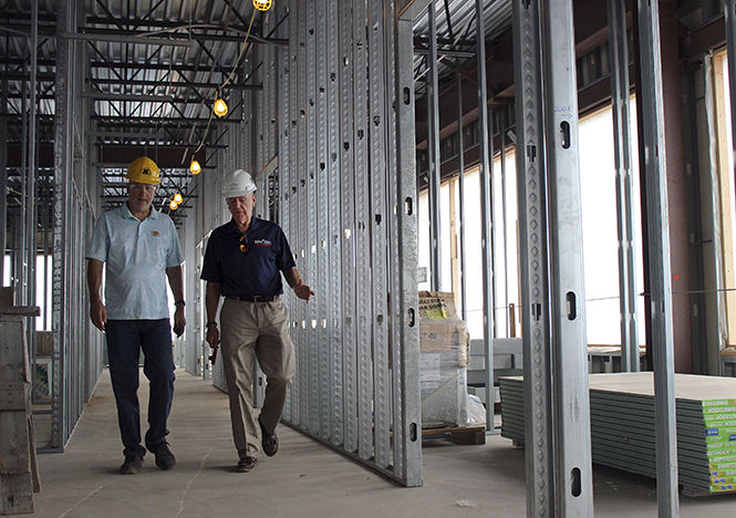 Joe Karpinski (left), Coordinator of Construction Management, and Robert Sines (right), dean of Kent State University's College of Applied Engineering, Sustainability and Technology, take a tour of the CAEST building during construction on July 11, 2014.