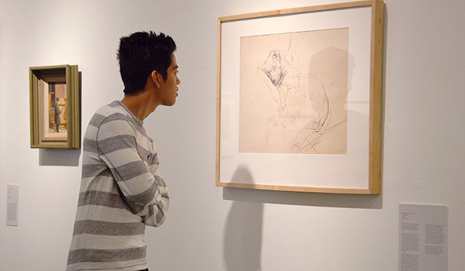 Mike Mandac, sophomore photo illustration major, stops by after class to view the The Legacy and Prospect exhibit on display in the art building Wednesday, Oct. 1 2014.