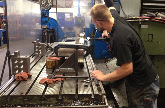 Coty Hartwell, a third-year apprentice at Colonial Machine Company in Kent, checks a gauge at the machine shop. Hartwell is working in Portage County's manufacturing sector and has replaced an aging population in the sector.