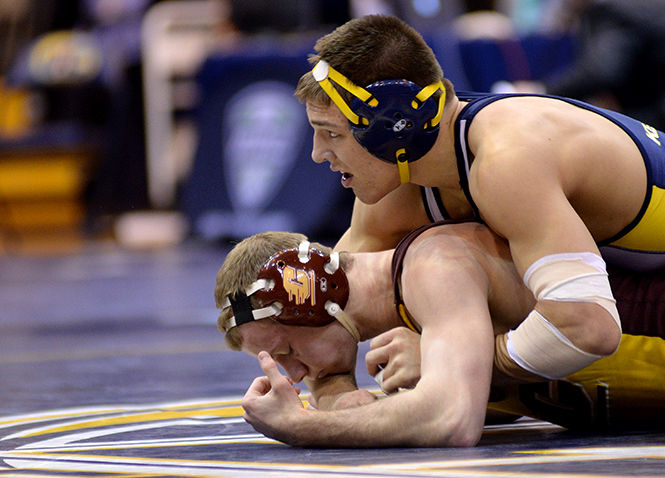 Kent State's Ian Miller pins his opponent and watches as the time ends in his final match of the MAC Championship Sunday, March 9, 2014. Miller defeated his opponent from Central Michigan and finished first in his weight class winning him a Mid-American Conference title.