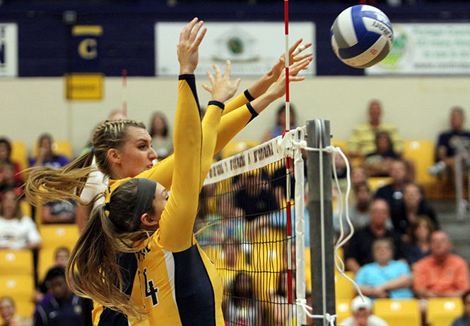 Kent State Senior middle blocker Liz Reikow and senior setter Jenny Buczek block the ball during a game against Morehead State Friday, September 5, 2014. The Flashes won 3-0.