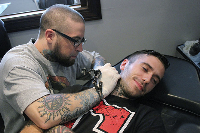 Tattoo artist Justin Evans tattoos Lee Vojack at Smokin' Tattooz, located at 100 E. Main St. Ohio recently passed new regulations regarding the cleanliness and sanitation of tattoo parlors that will be enforced by the Department of Health.  