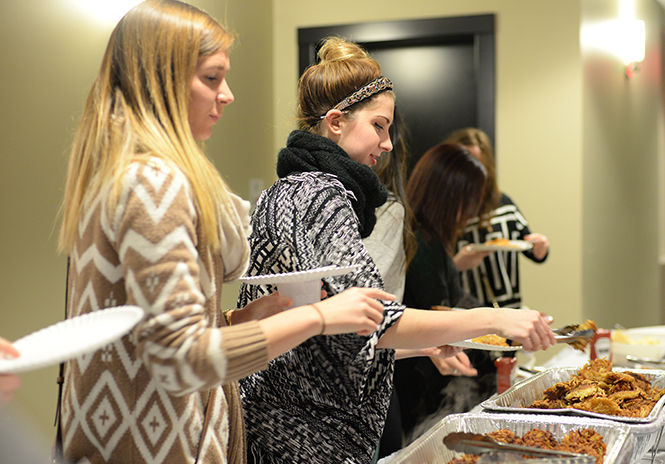 Senior fashion merchandising major Sarah Bouplon gets her latkes during Latkefest, Alpha Epsilon Pi's philanthropy event, hosted in Kent State Hillel on Thursday, Nov. 20, 2014.