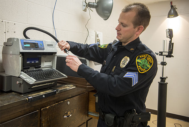 Sgt. Jason Short demonstrates how to work the Intoxilyzer 8000 Breathalyzer on Monday. Dec. 1, 2014 in the Kent City Police Station. The station does not use the machine, but in order to keep their permit they must test it on a weekly basis.