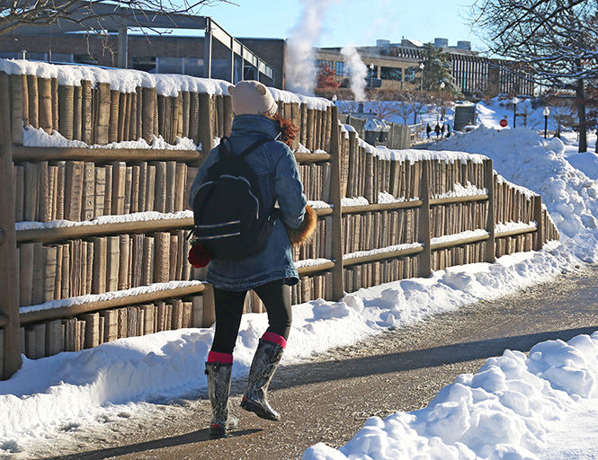 A student dresses for the cold as temperatures plunge below freezing in Kent.