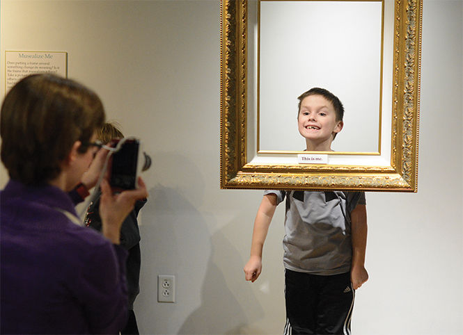 Max Kenworthy, age 7 from Kent, jumps into the air to get his head into an empty frame hanging in the new MuseLab art gallery in the School of Library and Information Science after putting the tag "this is me" on the frame Wednesday, Jan. 28, 2014.