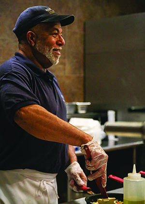 Steve Gilham, often known as "Steve the Omelet Guy" prepares an omelet at Eastway Café on Tuesday, Jan. 20, 2015. For the past seven years, Gilham has been serving breakfast to thousands of students. "It's rewarding," Gilham said. "I connect with a lot of students. It makes my job worthwhile."