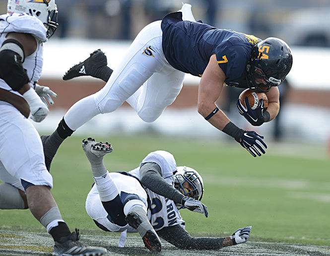 Casey Pierce leaps over Akron's Martel Durant at the Wagon Wheel game on Friday, Nov. 28, 2014 at Dix Stadium.