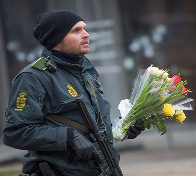 A policeman brings flowers to the scene of Saturday's terror attacks in Copenhagen, Denmark, on Sunday, Feb. 15, 2015. Police in Copenhagen say they have shot dead a man they believe was behind two deadly attacks in the Danish capital hours earlier. It came after one person was killed and three police officers injured at a free speech debate in a cafe on Saturday. In the second attack, a Jewish man was killed and two police officers wounded near the city's main synagogue. (Bjorn Kietzmann/Action Press/Zuma Press/TNS)