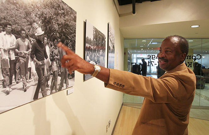 Lafayette Tolliver, a Kent State Univeristy alumus 1967-71 points out an old friend in one of the photos in an exhibit of his photographs called, "Coming of Age at Kent 1967-71 A pictorial of Black Student Life" in the Uumbaji Gallery in Oscar Ritchie Hall on Saturday Oct. 18, 2014 in Kent, Ohio. Tolliver worked as a photographer for the Daily Kent Stater and Chestnut Burr student year book during his time at the university. (Mike Cardew/Akron Beacon Journal)