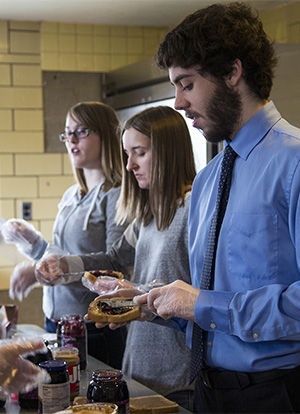  Physics major Paul Billig makes a peanut butter and jelly sandwich in the Newman Center on Saturday March 14, 2015. Students from the Christian Student Association and the Muslim Student Association worked together in this interfaith community serivce project and created hygine packs and lunches for underprivledged in the area.