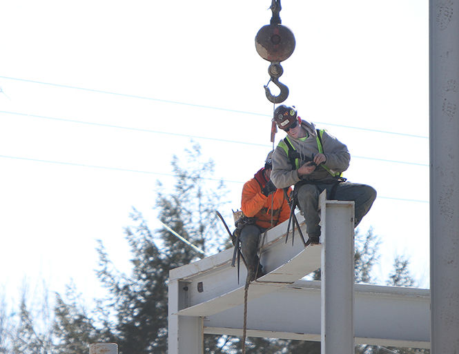 Two workers ontop of the Institutional Advancement Center being constructed along S. Lincoln St on March 11, 2015.