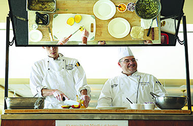 Chefs Andrew Eith and Timothy Wright prepare grilled fish tacos with mango slaw for a food demonstration introducing Kent State's new "mindful" menu items. Photo courtesy of Kent State Dining Services.