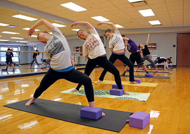 A group of students take a basic yoga class at the KSU Student Recreation and Wellness Center on Thursday, Jan. 22, 2015.