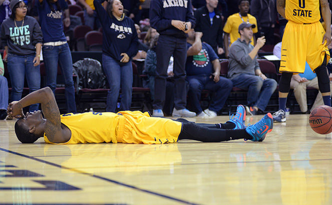 Chris Ortiz lays on the court after failing to get the final shot off in time at the quarter-final MAC Tournament game against the University of Akron on Thursday, March 12, 2015 in Quicken Loans Arena. The Flashes lost to the Zips 53-51.