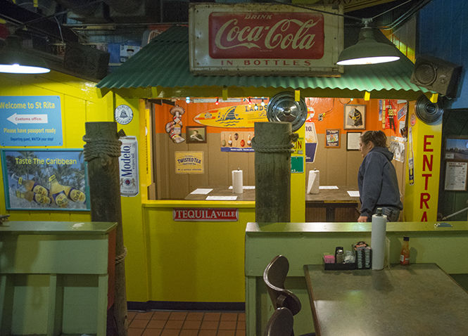 A waitress at Mike's Place cleans off a table during breakfast on Monday, April 6, 2015. Mike's Place, known for its unique seating, like eating inside a bus, and unique wall memorabilia, was awarded of the best place to cure a hangover in Kent.