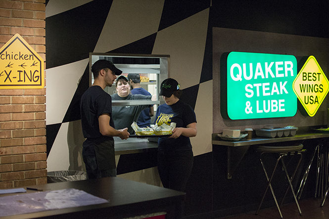 Quaker Steak &amp; Lube employee Grace Kober runs food to a table on Monday April 6, 2015. The on-campus restaurant serves wings, burgers, and more on the bottom level of the student center.