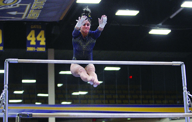 Kent State freshman Michaela Romito looks for the bar during her uneven bars routine on Sunday, Feb. 15, 2015, at the M.A.C. Center. Kent State lost to Central Michigan, 195.325-196.400.