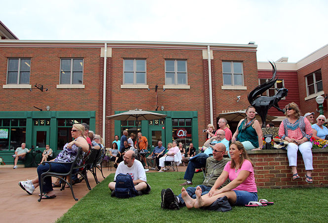 People sit and watch Jake Friel &amp; The Last Train South perform at Acorn Alley Plaza during Kent Blues Fest on Friday, July 17, 2015.