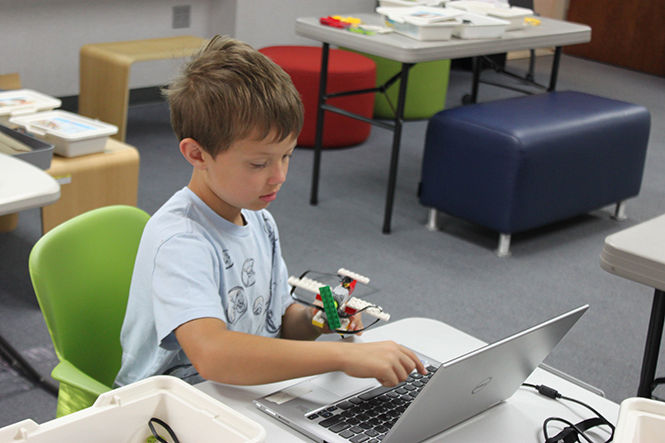 A camper builds a LEGO model during a LEGO WeDo Robotics Level 1 camp in the AT&amp;T Classroom of Moulton Hall on Monday, July 20, 2015.